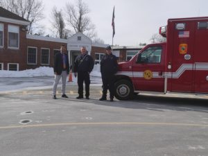 ambulance and staff standing in front of Moore school next to an ambulance